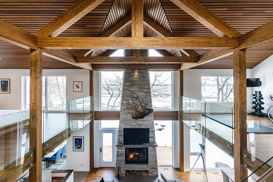 Immense espace de vie avec poutres et plafond en bois par Mino Design à Québec et Lévis.